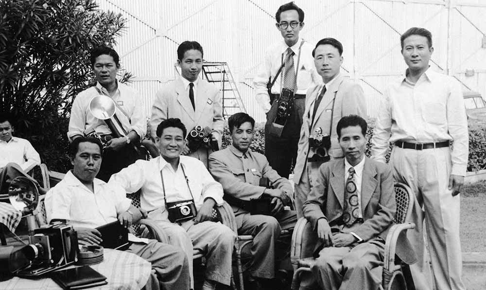 新華社記者錢嗣杰（站立者右二）在采訪會議開幕式后和外國記者在會場外休息。